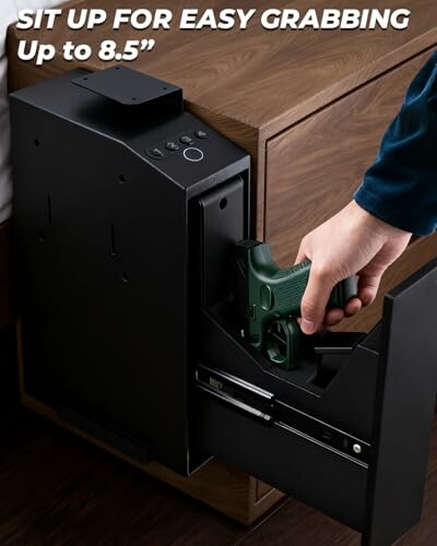 Hand accessing a gun in a bedside safe.