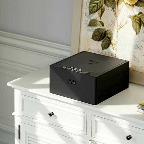 Black electronic device with buttons on a white cabinet.